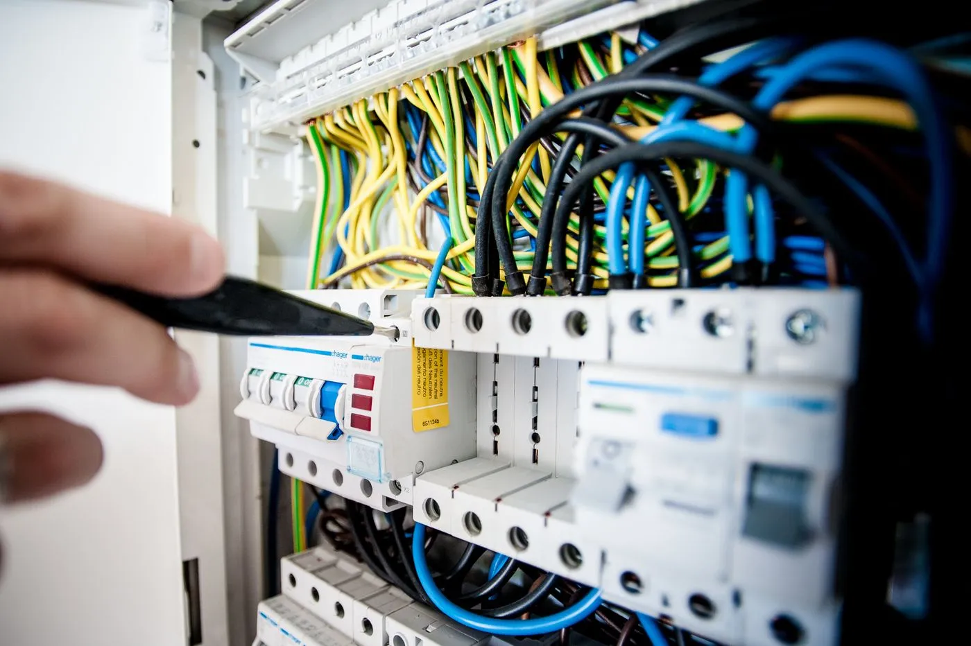 Électricien raccordant un tableau électrique dans un appartement à Paris